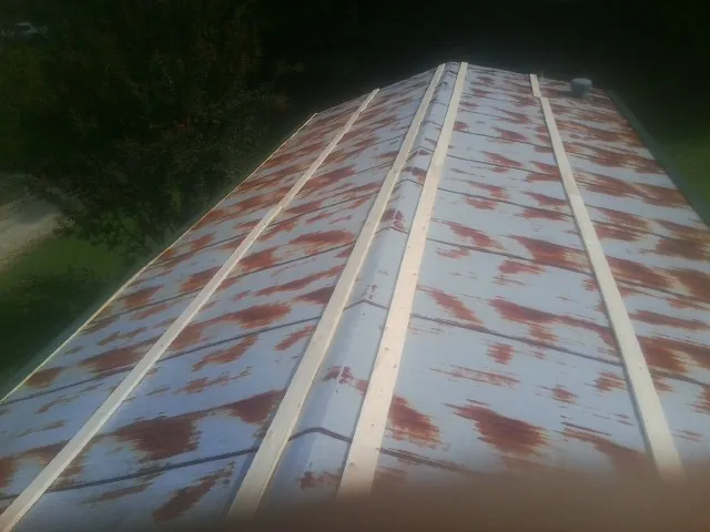 Rusted metal roof panels with new wood purlins before replacement — Storm Damage Roof Repair in Marble by Roofing Brothers