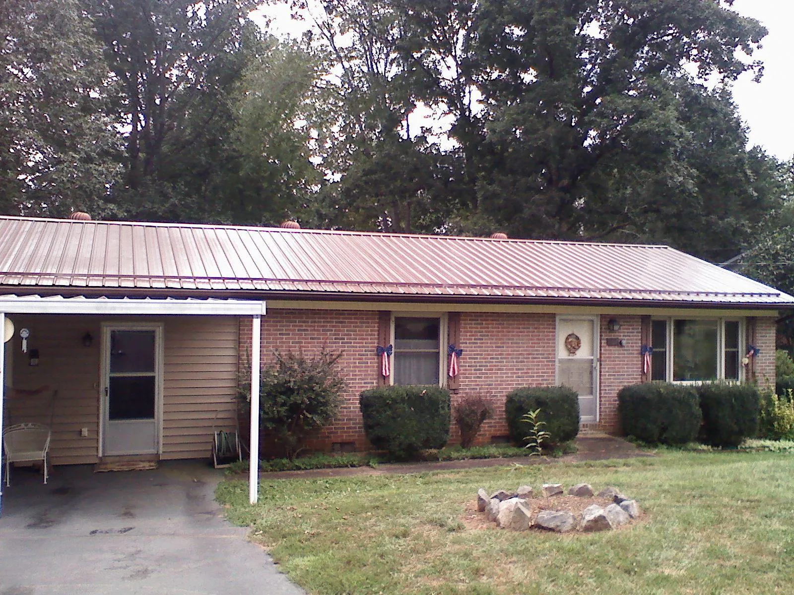 Bronze metal roof and carport on a brick ranch home — Roof Repair work by our crew in Marble